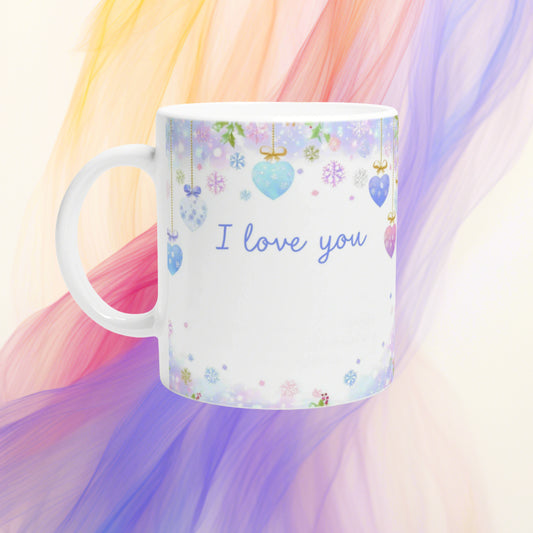 White mug mockup with I love you in blue cursive, surrounded by pastel hearts and snowflakes on a soft pastel backdrop.